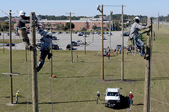 Electrical lineman on poles