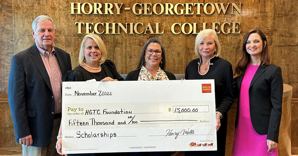 A giant check is presented to the college