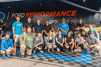 Automotive technology students posing with members of Ford