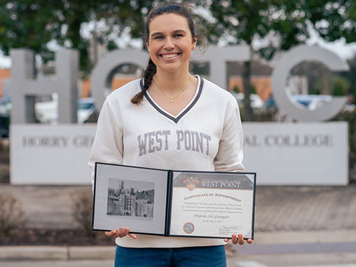 Woman holding her acceptance letter from west point.