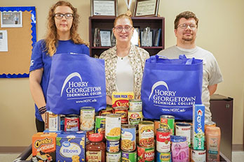 members of PTK standing in front of food donations