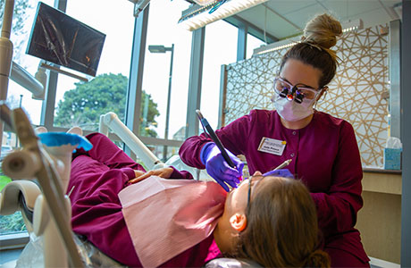  dental assistant works with patient
