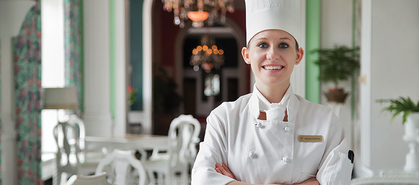 a professional chef smiles in front of tables